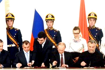 Un grupo de personas observan un discurso del presidente ruso, Vladimir Putin, ante la Asamblea Federal en Sevastopol