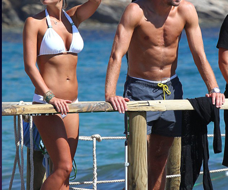 El futbolista vistió unos pantalones cortos olor azul oscuro y lentes de sol, mientras que su esposa lució su figura en un bikini blanco