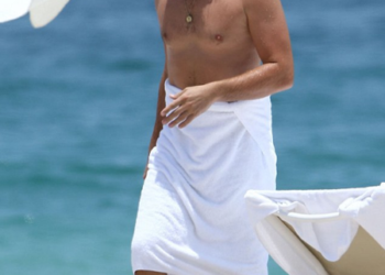 Leo se veía bien tímido, ató una toalla blanca alrededor de su barriga  mientras disfrutaba de un día en la playa en Miami