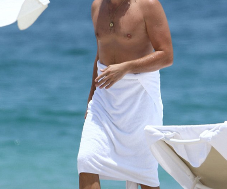 Leo se veía bien tímido, ató una toalla blanca alrededor de su barriga  mientras disfrutaba de un día en la playa en Miami