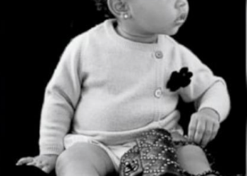 Con solo 14 meses, la pequeña posa luciendo un chaleco cardigan y una cartera negra Chanel.