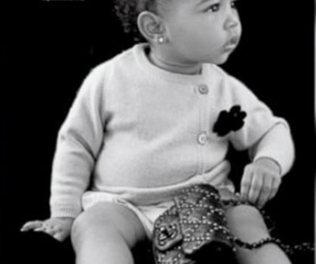 Con solo 14 meses, la pequeña posa luciendo un chaleco cardigan y una cartera negra Chanel.