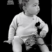 Con solo 14 meses, la pequeña posa luciendo un chaleco cardigan y una cartera negra Chanel.