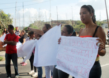 Al menos 30 madres se apostaron en la calle principal del sector  Las Dalias de Lagunetica para protestar por los presuntos traslados de sus hijos  a otros planteles educativos lejanos a sus hogares, puesto que la Unidad Educativa Juan Bautista Arismendi será demolida.