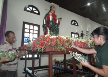 La cofradía de San Juan Evangelista trabajó ayer en el decorado de la imagen.