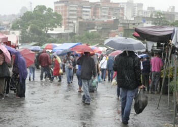 Con paraguas en mano salieron a hacer las compras dominicales