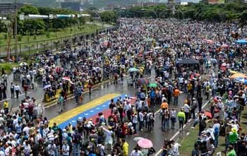 "PLANTÓN" EN CARACAS. Cubriéndose con paraguas o capas de la lluvia que ha caído de forma intermitente, miles de personas estuvieron apostadas en la neurálgica autopista Francisco Fajardo, en el este de Caracas.