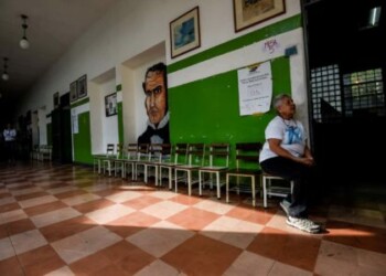 Una mujer espera en una casilla de votación vacía durante las elecciones presidenciales en Caracas / AFP PHOTO / Juan BARRETO