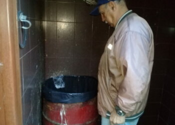 Vecino revisando el bote de basura luego de haber lanzado una bolsa