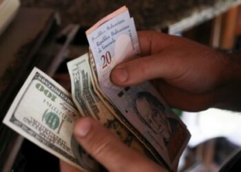 A cashier counts U.S. dollar and Venezuelan bolivar notes received from a customer in a bakery during an ongoing blackout in Caracas, Venezuela March 10, 2019. REUTERS/Manaure Quintero NO RESALES. NO ARCHIVES.
