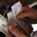A cashier counts U.S. dollar and Venezuelan bolivar notes received from a customer in a bakery during an ongoing blackout in Caracas, Venezuela March 10, 2019. REUTERS/Manaure Quintero NO RESALES. NO ARCHIVES.