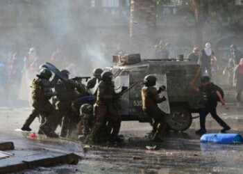 Demonstrators clash with riot police during a protest against the government in Santiago on November 22, 2019. - Chilean President Sebastian Pinera said on Thursday that police may have broken protocols in responding to a month of protests, and prosecutors will investigate whether they violated human rights. (Photo by Johan ORDONEZ / AFP)