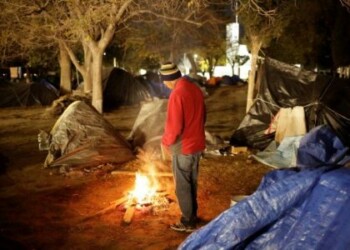 Foto de archivo de un hombre acampando en Ciudad Juárez mientras espera para solicitar una visa en EEUU calentándose junto a una fogata. Dic 17, 2019. 
REUTERS/Jose Luis Gonzalez