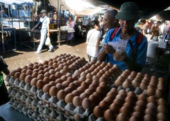 CRC07. CARACAS (VENEZUELA). 29/07/18.- Fotografía fechada el 21 de julio de 2018 que muestra a un hombre que cuenta billetes en el mercado de Las Pulgas, en Maracaibo (Venezuela). En Venezuela quien paga un producto en efectivo lo obtiene a menor precio y esta situación se puede ver claramente en el mercado popular de Las Pulgas en la ciudad occidental de Maracaibo donde hay carteles que anuncian "ofertas" condicionadas al trance con billetes. EFE/Humberto Matheus