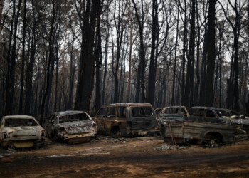 This picture taken on January 6, 2020 shows charred vehicles gutted by bushfires in Mogo Village in Australia's New South Wales state. - Firefighters were racing to contain massive bushfires across southeastern Australia Tuesday amid easing conditions as another heatwave loomed, as officials said the damage bill for the months-long crisis had risen to almost half a billion dollars. (Photo by SAEED KHAN / AFP)