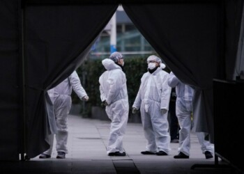 Staff members wearing protective masks are seen at the Shanghai railway station in Shanghai, China, as the country is hit by an outbreak of a new coronavirus, February 7, 2020. REUTERS/Aly Song