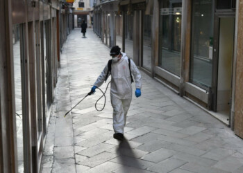 An employee of the municipal company Veritas sprays disinfectant in public areas in Venice on March 11, 2020, as part of precautionary measures against the spread of the new coronavirus COVID-19, a day after Italy imposed unprecedented national restrictions on its 60 million people Tuesday to control the deadly COVID-19 coronavirus. (Photo by MARCO SABADIN / AFP)