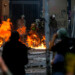 Riot police are reached by a petrol bomb during clashes with demonstrators protesting, in Santiago, on November 8, 2019. - Unrest began in Chile last October 18 with protests against a rise in transport tickets and other austerity measures that descended into vandalism, looting, and clashes between demonstrators and police. (Photo by JAVIER TORRES / AFP)