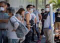 Decenas de personas con tapabocas hacen fila este miÈrcoles para abastecerse de medicamentos y productos de higiene personal en una farmacia de Caracas (Venezuela). EFE/Rayner PeÒa