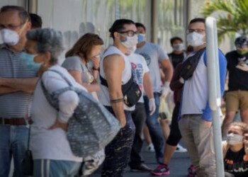 Decenas de personas con tapabocas hacen fila este miÈrcoles para abastecerse de medicamentos y productos de higiene personal en una farmacia de Caracas (Venezuela). EFE/Rayner PeÒa