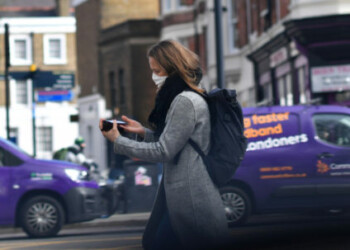A woman wearing a face mask walks through central London as the number of coronavirus cases grow around the world, in London, Britain, March 17, 2020. REUTERS/Dylan Martinez