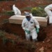 Sepultureros con trajes protectores preparan el entierro de una persona fallecida por coronavirus en el cementerio de Sao Paulo. Mayo 22, 2020. REUTERS/Amanda Perobelli