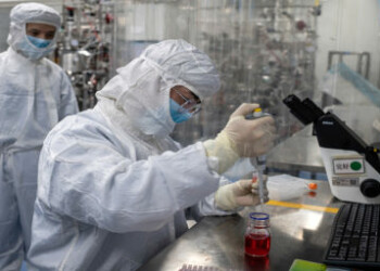 (FILES) This file photo taken on April 29, 2020 shows an engineer taking samples of monkey kidney cells as he make tests on an experimental vaccine for the COVID-19 coronavirus inside the Cells Culture Room laboratory at the Sinovac Biotech facilities in Beijing. - China has mobilised its army and fast-tracked tests in the global race to find a coronavirus vaccine, and is involved in several of the dozen or so international clinical trials currently under way. (Photo by NICOLAS ASFOURI / AFP) / TO GO WITH Health-virus-China-vaccines,FOCUS by Ludovic EHRET