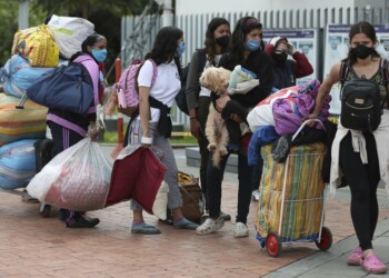 Venezuelan migrants wait for a bus to travel to the border, after breaking camp in Bogota, Colombia, Thursday, July 2, 2020. Facing no work due to the COVID-19-related economic shutdown, hundreds of Venezuelan migrants are returning to their country. (AP Photo/Fernando Vergara)