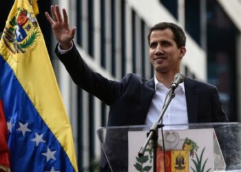 Venezuela's National Assembly head Juan Guaido waves to the crowd during a mass opposition rally against leader Nicolas Maduro in which he declared himself the country's "acting president", on the anniversary of a 1958 uprising that overthrew military dictatorship, in Caracas on January 23, 2019. - "I swear to formally assume the national executive powers as acting president of Venezuela to end the usurpation, (install) a transitional government and hold free elections," said Guaido as thousands of supporters cheered. Moments earlier, the loyalist-dominated Supreme Court ordered a criminal investigation of the opposition-controlled legislature. (Photo by Federico PARRA / AFP)