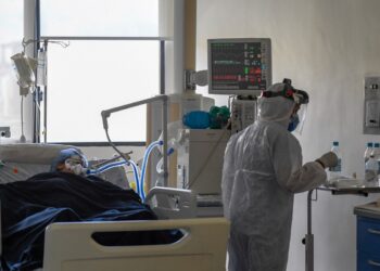 A medical staff tends to a patient at the intensive care unit for patients patients infected with Covid-19 at the Trinidad Teaching Medical Center, in Caracas, on March 19, 2021. (Photo by Federico PARRA / AFP)