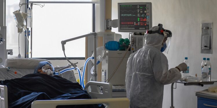 A medical staff tends to a patient at the intensive care unit for patients patients infected with Covid-19 at the Trinidad Teaching Medical Center, in Caracas, on March 19, 2021. (Photo by Federico PARRA / AFP)