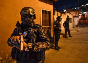 Members of Venezuelan Scientific Police (CICPC) take part in an operation amid the COVID-19 pandemic in Los Teques, Miranda state, Venezuela, on March 20, 2021. - In Miranda there is a circulation restriction since 18h00, there is the order to close stores at 16h00, to wear face masks and to prevent meetings of more than five people, amid a second wave of the COVID-19 pandemic. (Photo by Federico PARRA / AFP)