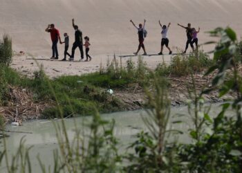 Venezuelan migrants gesture after crossing the Rio Bravo, or Rio Grande as it is called in the US, into the United States to seek for political asylum, as seen from Ciudad Juarez, Chihuahua State, Mexico, on September 12, 2022. (Photo by Herika MARTINEZ / AFP)