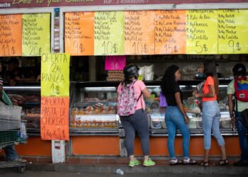 AME9701. CARACAS (VENEZUELA), 02/07/2021.- Varias personas compran en una carnicería el 25 de junio de 2021, en Caracas (Venezuela). Venezuela lleva inmersa en la pesadilla de la hiperinflación desde noviembre de 2017, una época de cifras mareantes que ha derivado en una dolarización espontánea como boya de salvación. Sin embargo, en los últimos meses, el incremento de los precios ha comenzado a frenarse, lo que alimenta la esperanza de dejar atrás el mal sueño. EFE/ Rayner Peña R