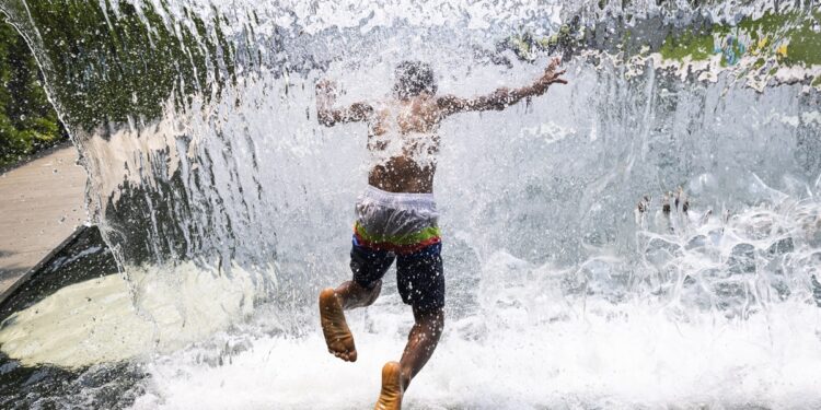 WASHINGTON (ESTADOS UNIDOS), 18/07/2023.- Un niño se refresca en una fuente con cascada en Yards Park, Washington (Estados Unidos). El hemisferio norte, que apenas lleva un mes bajo el solsticio de verano, se asfixia bajo unas temperaturas diurnas de récord y un calor nocturno tropical, peligroso para la salud, según dijo este martes la Organización Meteorológica Mundial (OMM). El calor sofocante se ha instalado en media Europa estos días, pero también en Estados Unidos y otras zonas de Asia y África, con temperaturas diurnas de récord y noches tropicales, lo que ha despertado una creciente preocupación por las consecuencias que pueda tener en la salud. EFE/ Jim Lo Scalzo