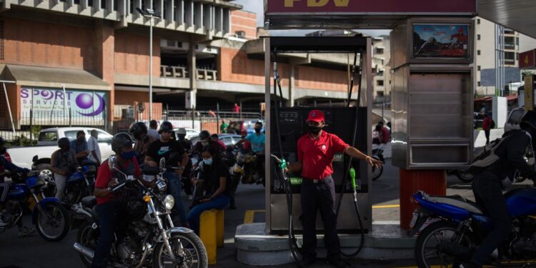 Motorcyclists queue to fill the tank of their bikes in a gas station in Caracas on October 5, 2020, amid the new coronavirus pandemic. - Venezuela launched this Monday a plan to distribute gasoline according to the registration numbers of the vehicles, a measure in response to the severe fuel shortage in the Caribbean country. (Photo by Cristian Hernandez / AFP)