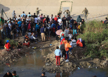 MEX5196. CIUDAD JUÁREZ (MÉXICO), 13/09/2023.- Un grupo de migrantes permanecen a un costado de la frontera con Estados Unidos, en Ciudad Juárez, Chihuahua (México). La desesperación de los migrantes por pasar a Estados Unidos a través de la mexicana Ciudad Juárez ha aumentado lo que ha provocado que muchos pongan en riesgo su vida al intentan cruzar a través de las peligrosas barricadas construidas con alambrada de navajas. EFE/Luis Torres